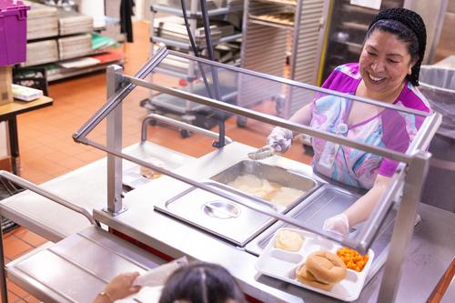 A staff member serves lunch